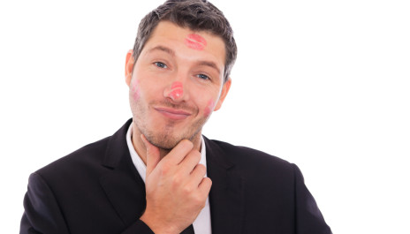 Macho mit Lippenstift-Abdrücken im Gesicht